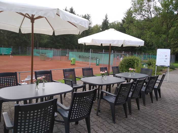 Die Terasse des Tennis-Vereinsheims mit Sonnenschirmen.